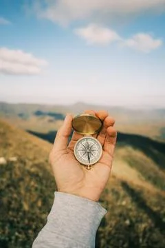 Compass in hand in the background mountain landscape. Stock Photos