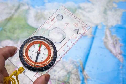 Compass in hand on a map background. Stock Photos