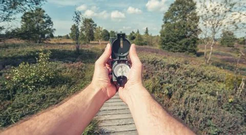 Compass in the hand on the nature background Фото