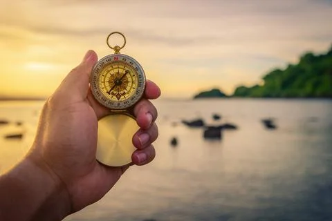 Compass in the hand on the nature background. Stock Photos