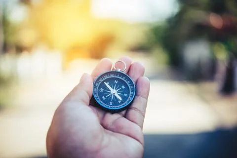 Compass in the hand ,Tourists hold a compass and locate a place Stock Photos
