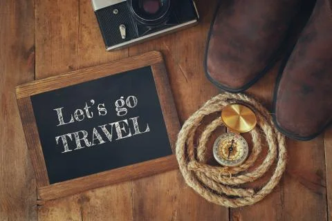 Compass, hiking boots, old camera and blackboard with quote Stock Photos