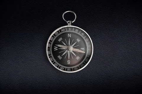 Compass isolated on dark background. Close-up Stock Photos