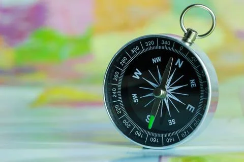Compass laid on a paper map. Stock Photos