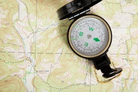 Compass laying on a map Stock Photos