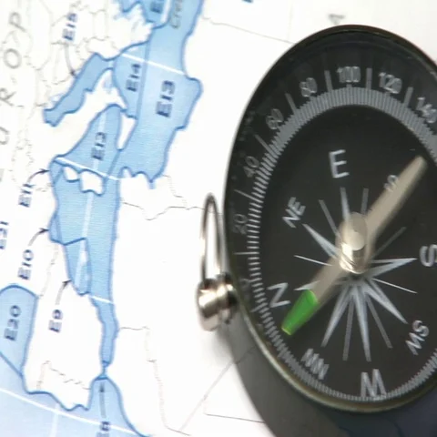 Compass left panning on the world map searching the north Stock Footage 69737169