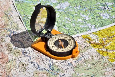 Compass lies on a topographic map. Stock Photos