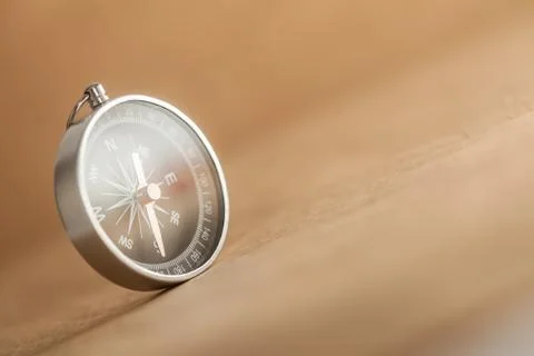 Compass on light brown background Stock Photos