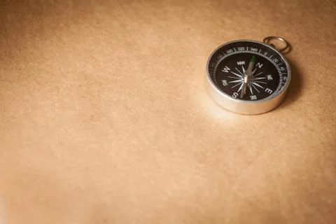 Compass on light brown background Stock Photos