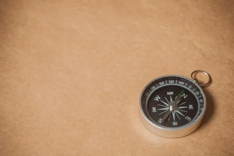Compass on light brown background Stock Photos