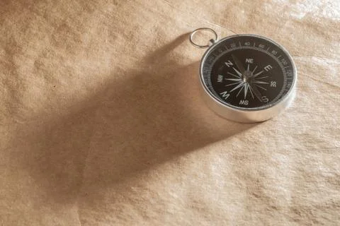 Compass on light brown background Stock Photos