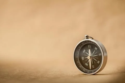 Compass on light brown background Stock Photos