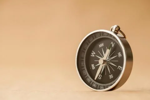 Compass on light brown background Stock Photos