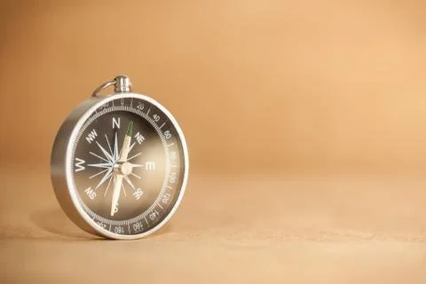 Compass on light brown background Stock Photos