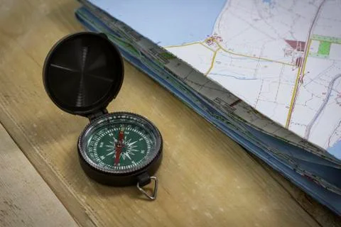 Compass with a map on the table Stock Photos