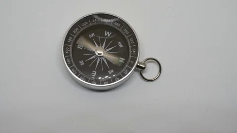 Compass needle spinning fast on white background Stock Footage 81599116