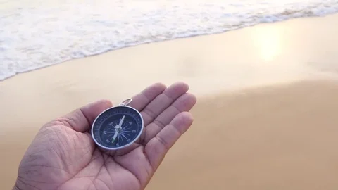 A compass in the palm of my hand that is looking for a destination on the beach Vidéo 77567166