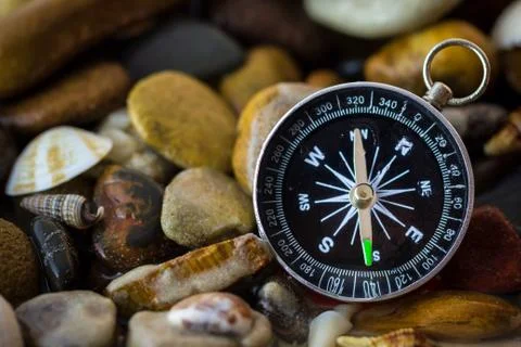 Compass on the pebbles and shell at riverside. Foto stock
