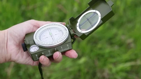 Compass in a person's hands. Person navigate the terrain using a compass Stock Footage 340141882