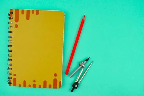Compass placed besides pencil and a orange color note paper diary on a light Foto stock