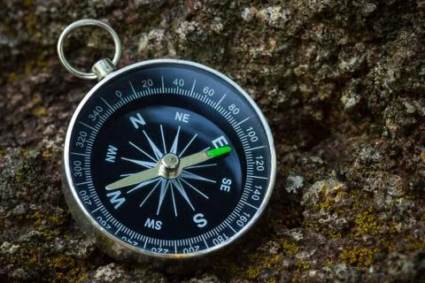 Compass placed on the rock in forest. Stock Photos