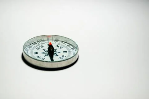 A compass pointing North on a plain white background with empty space Stock Photos