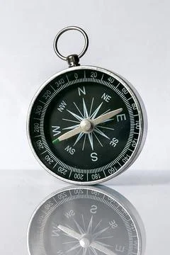Compass with Reflection on Grey Background. Navigation and Direction Concept Stock Photos