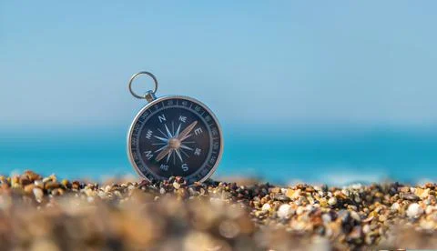 Compass on the sea beach. Selective focus. Stock Photos