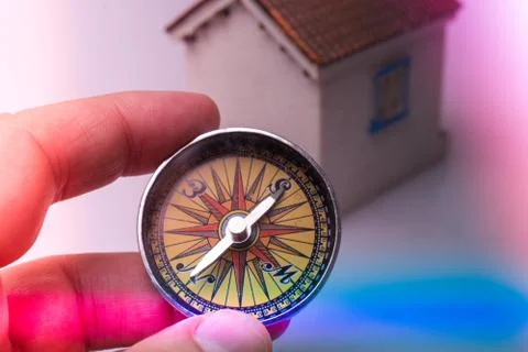 Compass tool in hand  before a model house Stock Photos