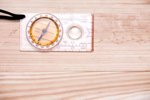 Compass in top left corner on a light wooden background. Copy space. Flat lay Foto stock