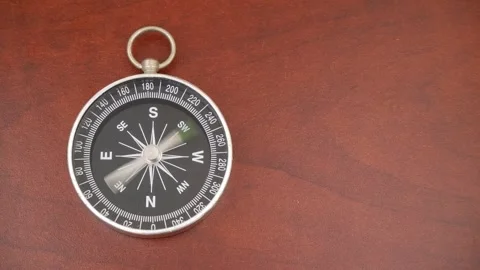 Compass on wooden table with rotating pointer Stock Footage 269894084