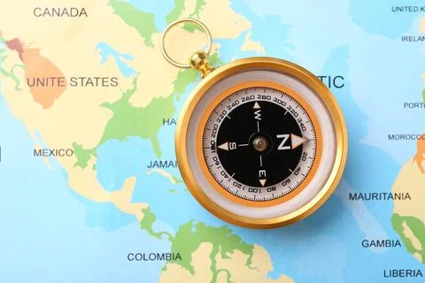 Compass on world map, top view. Navigation equipment Stock Photos