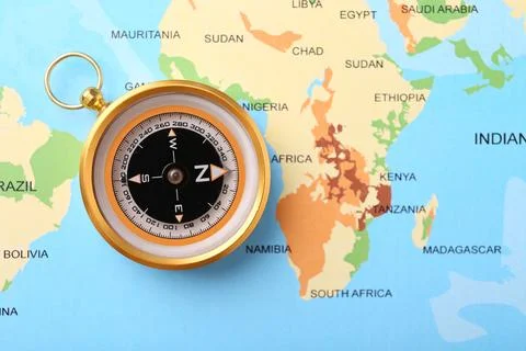 Compass on world map, top view. Navigation equipment Stock Photos