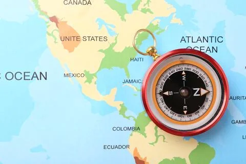 Compass on world map, top view. Navigation equipment Stock Photos