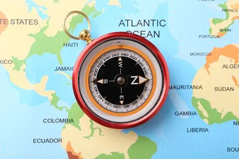 Compass on world map, top view. Navigation equipment Stock Photos