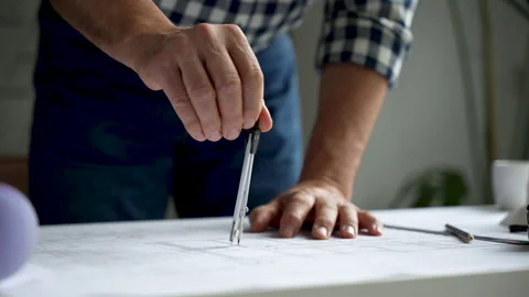 The compasses in the hands of an engineer. Architect working on blueprint Stock Footage 231484242