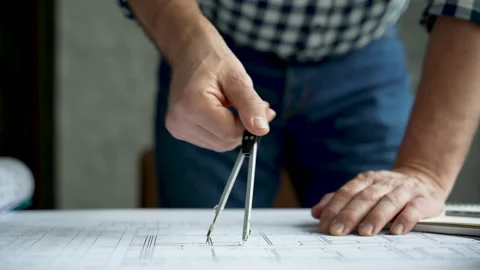 The compasses in the hands of an engineer. Architect working on blueprint Video stock 231484656