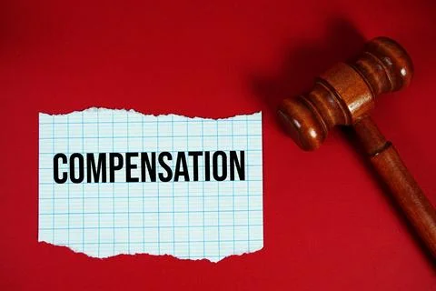 Compensation text written on rip paper with wooden judgment gavel on red ba.. Stock Photos