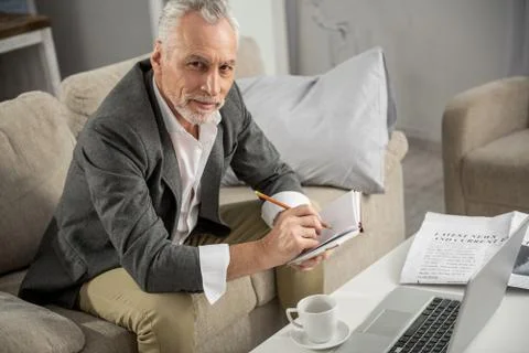 Competent businessman making important notes Stock Photos
