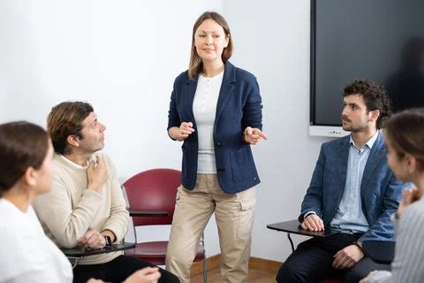 Competent female tutor teaching students in college classroom Stock Photos