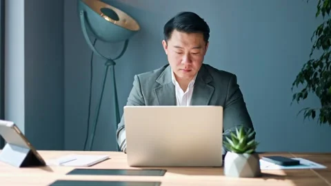 Competent male looking at window while typing on wireless laptop indoors Video stock 275225478