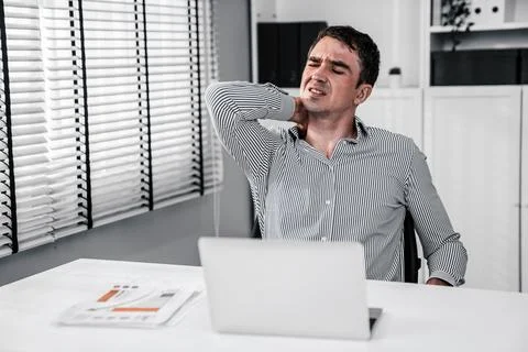 Competent office worker experiencing fatigue and neck pain. Stock Photos