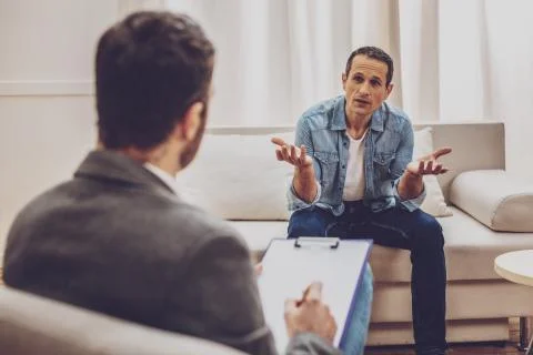 Competent practitioner solving problems with visitor Foto stock