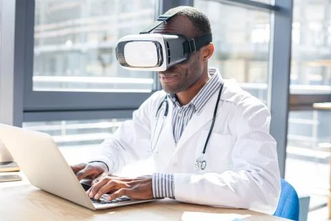 Competent young practitioner testing VR glasses Stock Photos