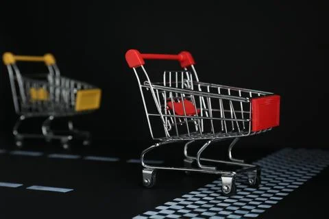 Competition concept. Shopping carts racing towards finish line Stock Photos