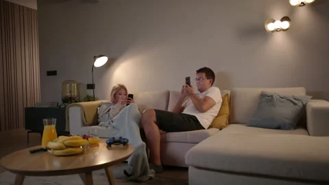 Competitive Couple Playing Mobile Games On Their Smartphones At Home Stock-Footage 135738697