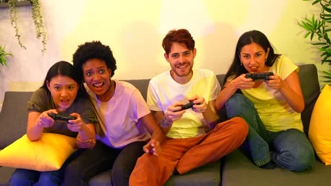 Competitive multi-ethnic friends playing console at home Stock Footage 261012754