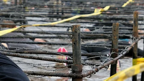 Competitors Crawling In Mud Under Barbed Wire In Obstacle Endurance Race Stock Footage 85399958