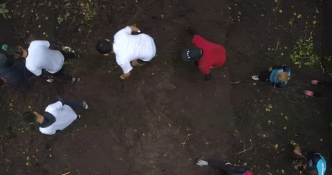 Competitors jump over a big ditch. Obstacle course. Aerial view, 4K. Stock Footage 124041933
