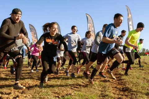 Competitors Sprint From Start Line At Obstacle Course Race Foto stock